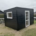 Opførsel af Anneks, isoleret skur. Montering af vinduer og døre. Husene er opført ved Ejstrup Strand